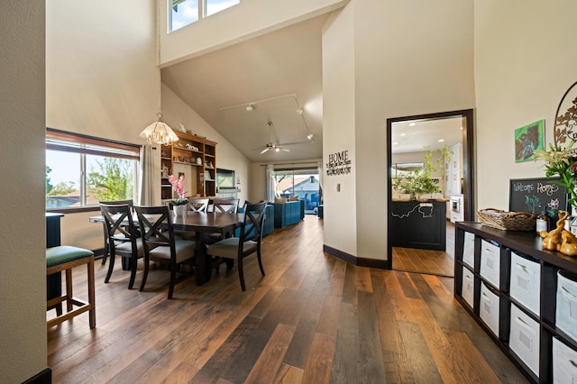 dining space featuring ceiling fan with notable chandelier, dark hardwood / wood-style floors, and high vaulted ceiling