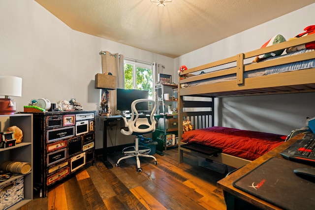 bedroom featuring a textured ceiling and dark hardwood / wood-style floors