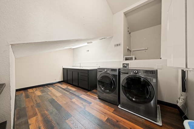 washroom with cabinets, sink, dark wood-type flooring, and washer and dryer