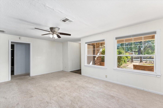 unfurnished room featuring ceiling fan, carpet floors, and a textured ceiling