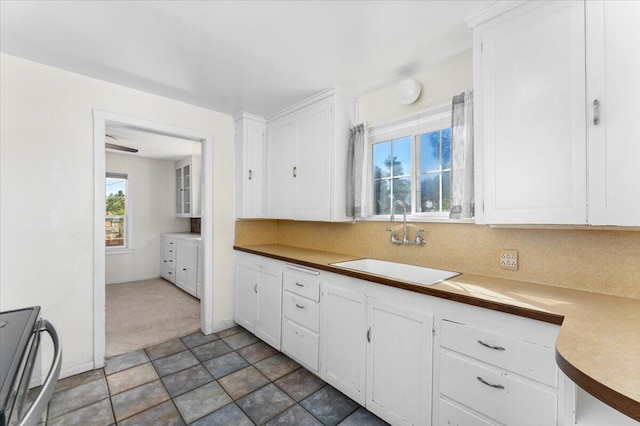 kitchen featuring white cabinetry, sink, and stainless steel range oven