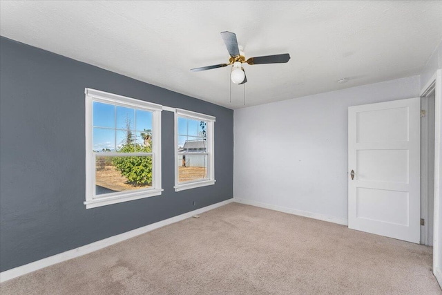 carpeted spare room featuring ceiling fan