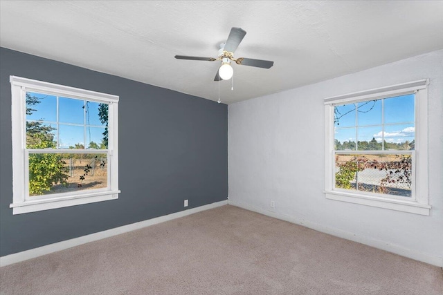 spare room featuring light carpet, plenty of natural light, and ceiling fan