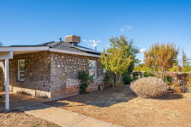 view of side of home with solar panels