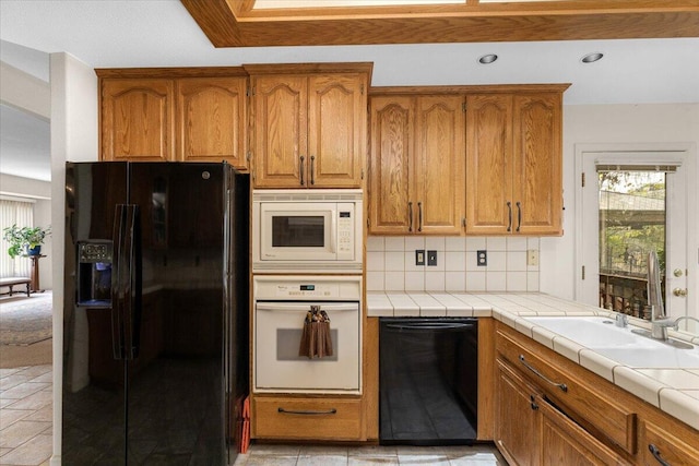 kitchen featuring backsplash, tile counters, and black appliances