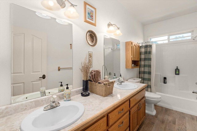 full bathroom featuring hardwood / wood-style floors, vanity, shower / tub combo with curtain, and toilet