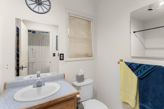 bathroom with vanity, walk in shower, and toilet