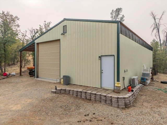 view of outdoor structure featuring central air condition unit and a garage