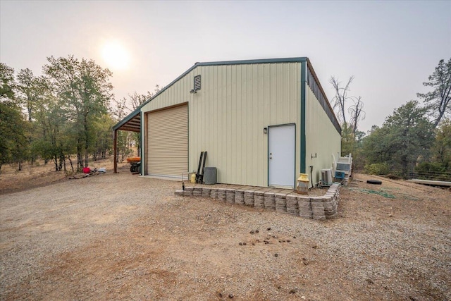 outdoor structure at dusk featuring a garage and central AC