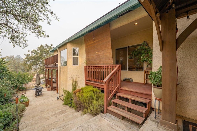 property entrance featuring a deck and a patio area