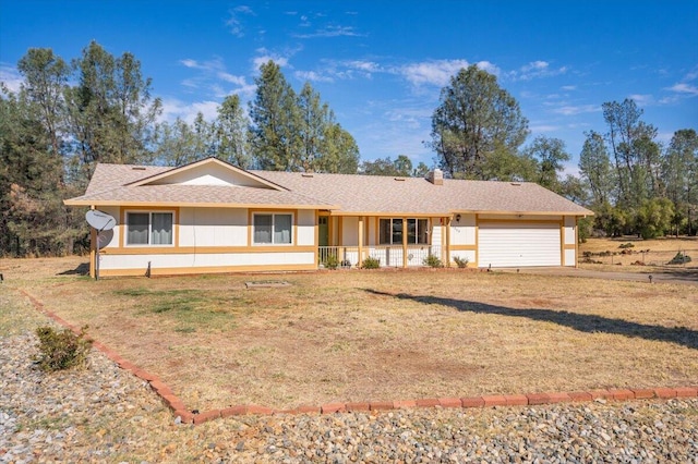 ranch-style home featuring a garage, a front lawn, and covered porch