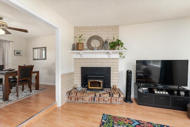 living room with ceiling fan, wood-type flooring, and a textured ceiling