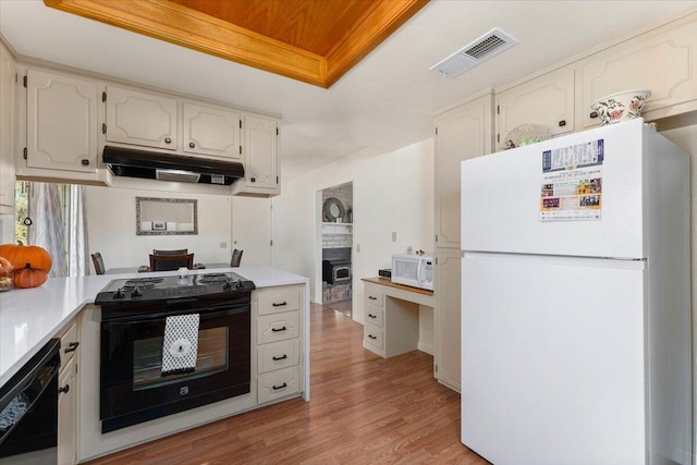 kitchen with white cabinets, black appliances, and light hardwood / wood-style flooring