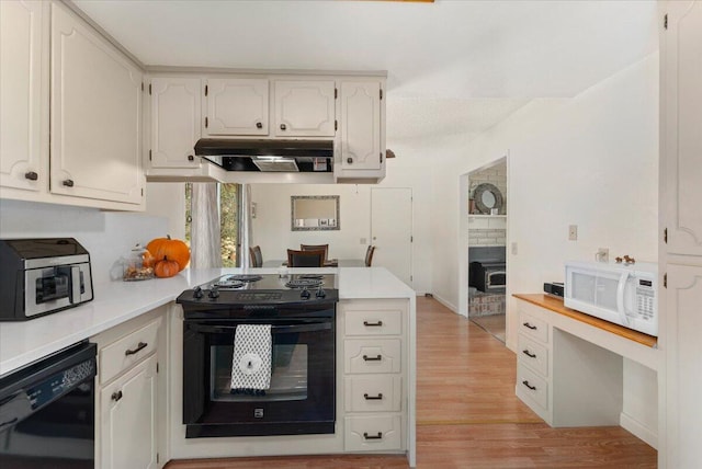 kitchen with extractor fan, light hardwood / wood-style floors, black appliances, and white cabinetry