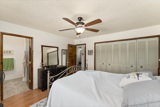 bedroom featuring light wood-type flooring, ceiling fan, a closet, and a textured ceiling