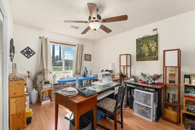 office space with ceiling fan, a textured ceiling, and light hardwood / wood-style floors