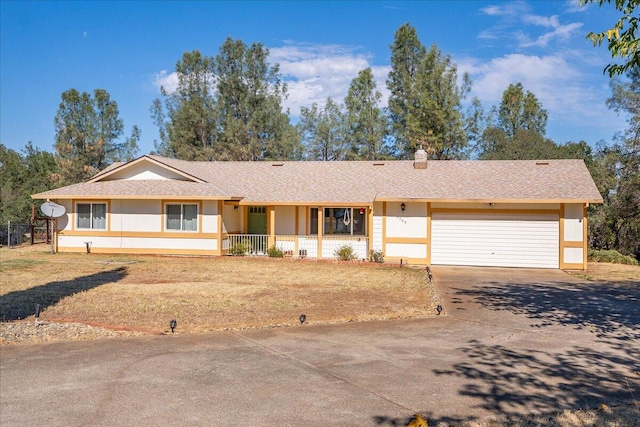 ranch-style home featuring a garage, a front lawn, and covered porch