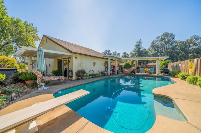 view of swimming pool featuring a diving board, a patio, and a pergola