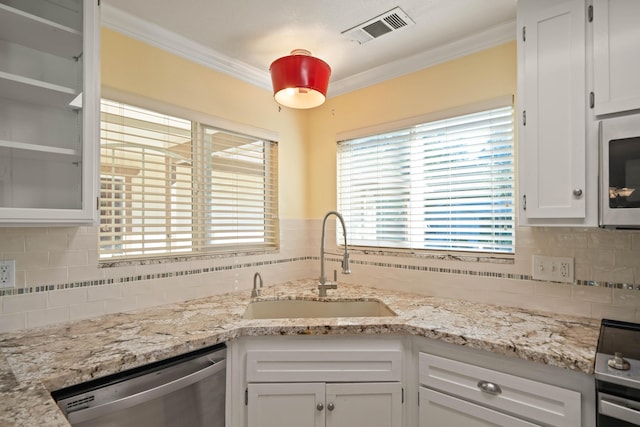 6849 Creekside St, Redding, CA 96001 - kitchen with appliances with stainless steel finishes, a sink, white cabinets, ornamental molding, and backsplash