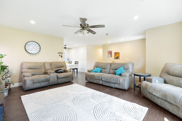 living room featuring dark wood-type flooring and ceiling fan