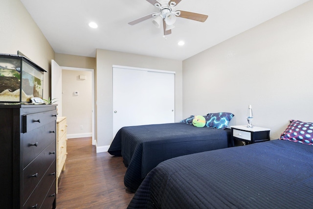 bedroom with ceiling fan, a closet, and dark wood-type flooring