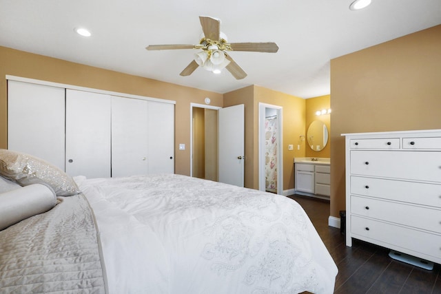 bedroom with ceiling fan, ensuite bath, and dark hardwood / wood-style floors