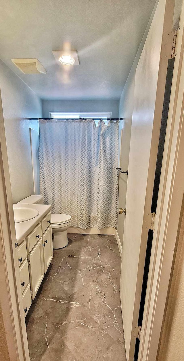 full bathroom featuring vanity, shower / tub combo, and toilet