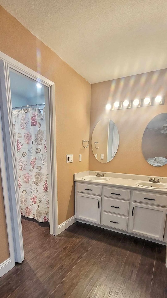 bathroom with hardwood / wood-style flooring, vanity, a shower with shower curtain, and a textured ceiling