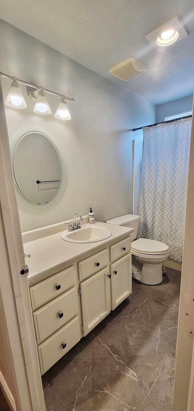 bathroom featuring toilet, vanity, and a shower with shower curtain