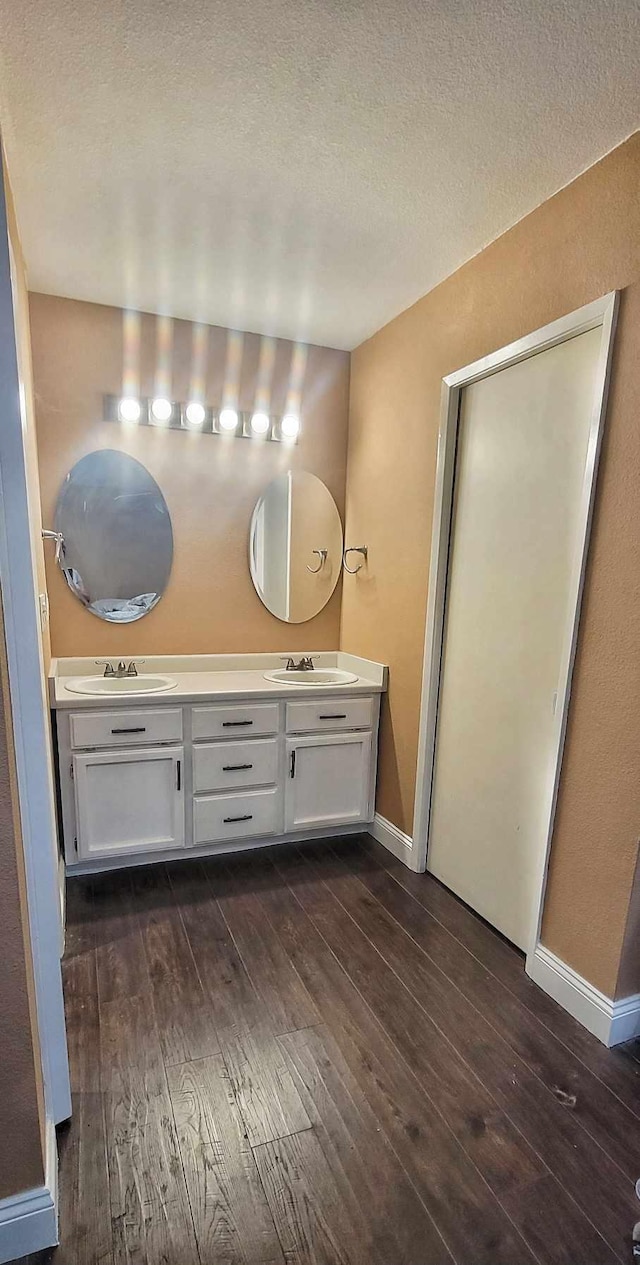 bathroom featuring vanity, wood-type flooring, and a textured ceiling