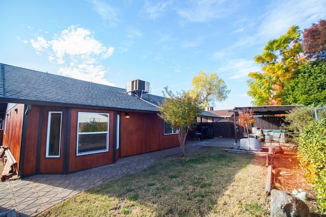 back of property with cooling unit, a yard, and a patio area