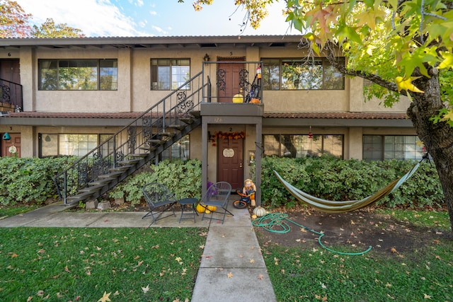 multi unit property with a patio and a front yard