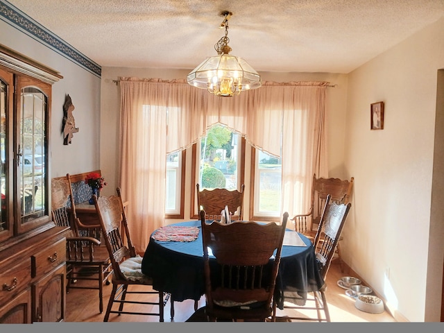 dining space featuring a textured ceiling and an inviting chandelier