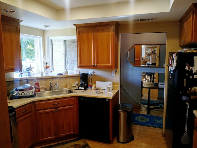 kitchen featuring sink, black appliances, and light wood-type flooring