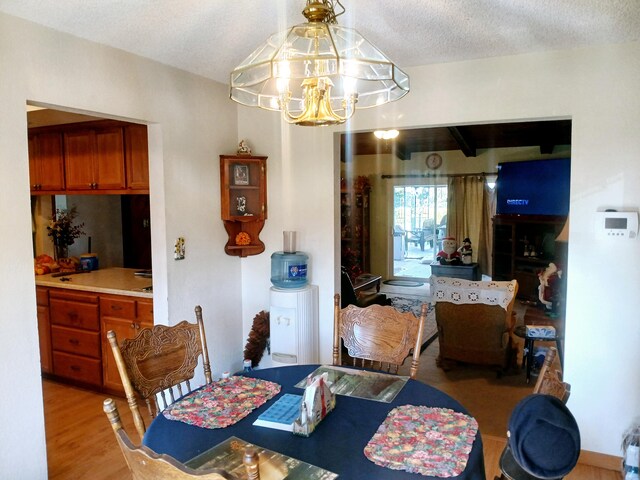 dining room featuring a chandelier, a textured ceiling, and light hardwood / wood-style floors