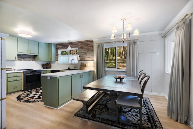 kitchen featuring light hardwood / wood-style flooring, black electric range oven, green cabinets, and pendant lighting