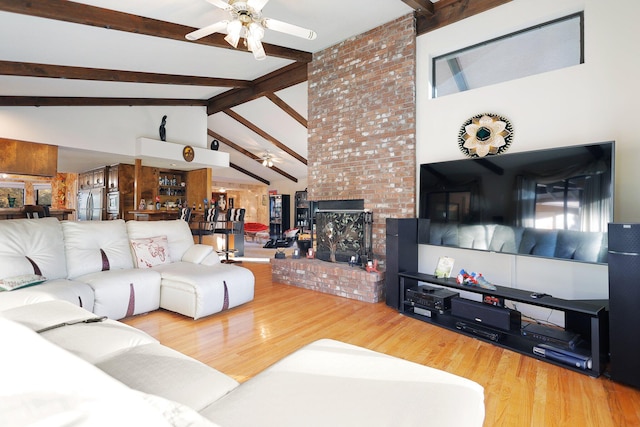 living room with beamed ceiling, wood-type flooring, and ceiling fan