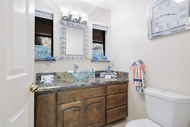 bathroom with tile patterned flooring, vanity, toilet, and plenty of natural light