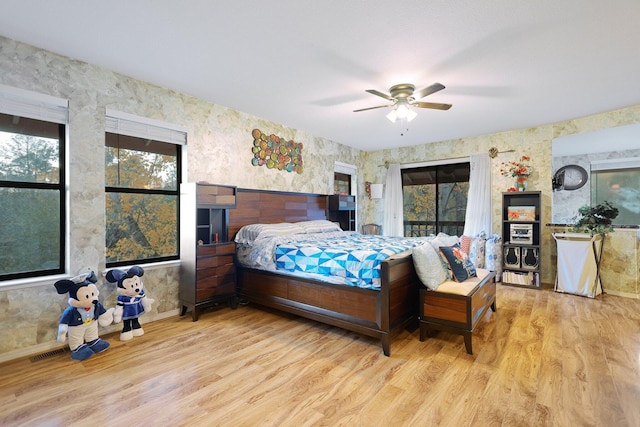 bedroom featuring multiple windows, light hardwood / wood-style flooring, and ceiling fan