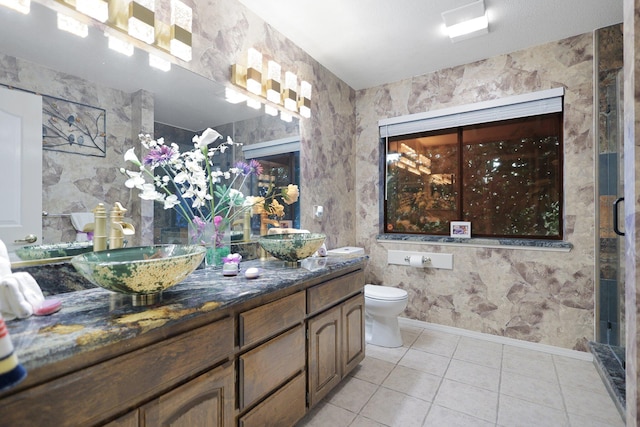 bathroom with tile patterned flooring, vanity, toilet, and a shower with shower door