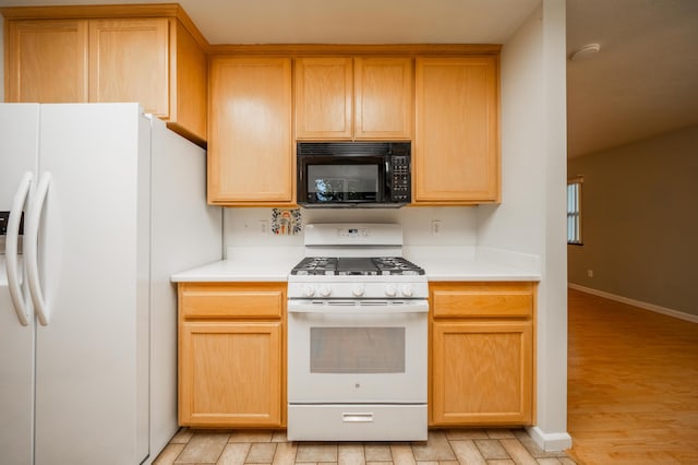 kitchen featuring light brown cabinetry, white appliances, and light hardwood / wood-style floors