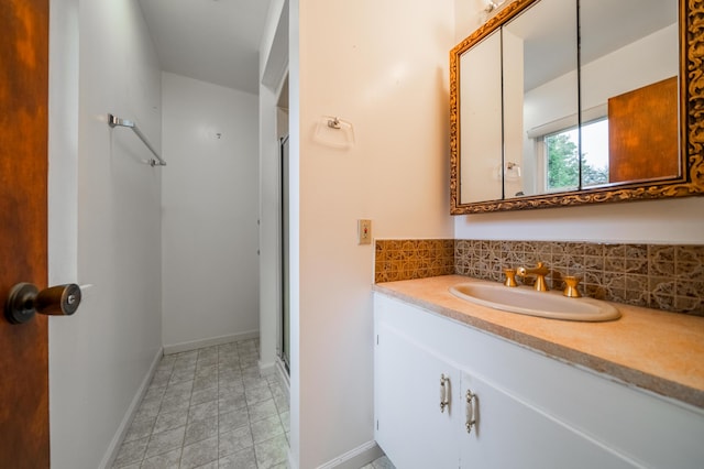 bathroom with vanity, tasteful backsplash, and a shower with door