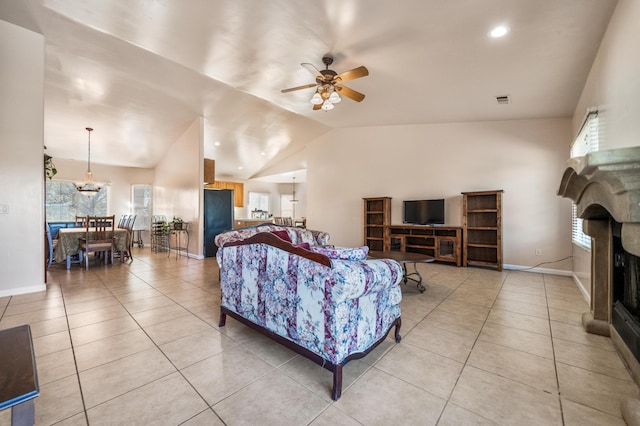 living room featuring light tile patterned flooring, ceiling fan with notable chandelier, and vaulted ceiling