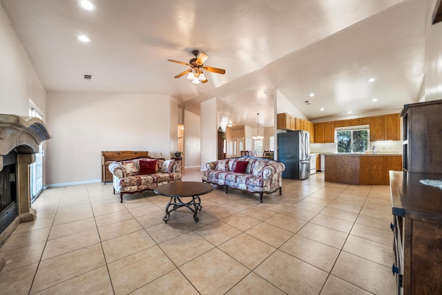 living room with ceiling fan, light tile patterned flooring, and vaulted ceiling