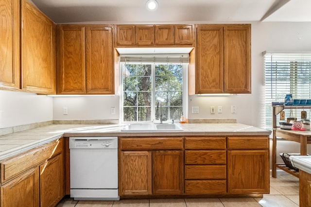 kitchen featuring dishwasher, sink, and light tile patterned floors