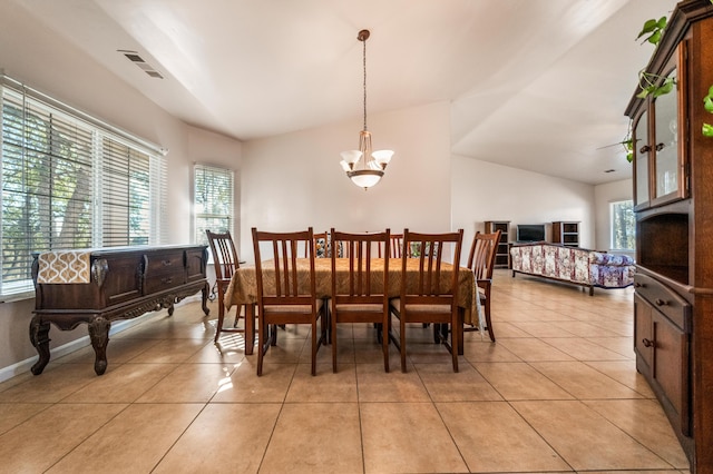 dining room featuring a healthy amount of sunlight, light tile patterned floors, and vaulted ceiling