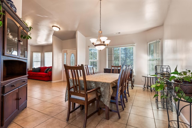 tiled dining room featuring a notable chandelier