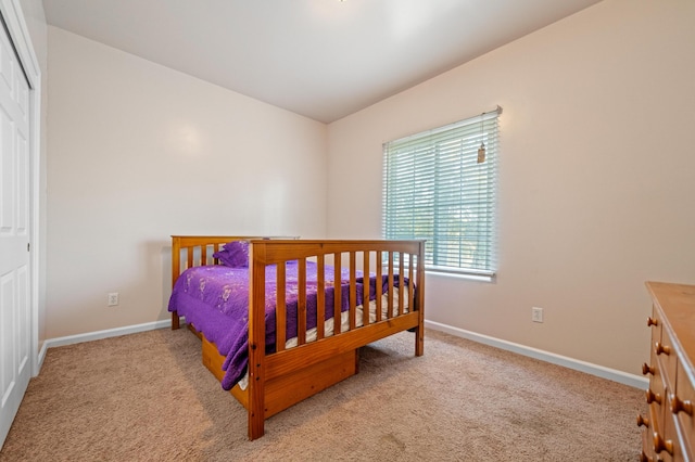 bedroom featuring light colored carpet and a closet