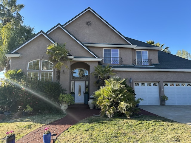 front of property featuring a garage, a front yard, and a balcony