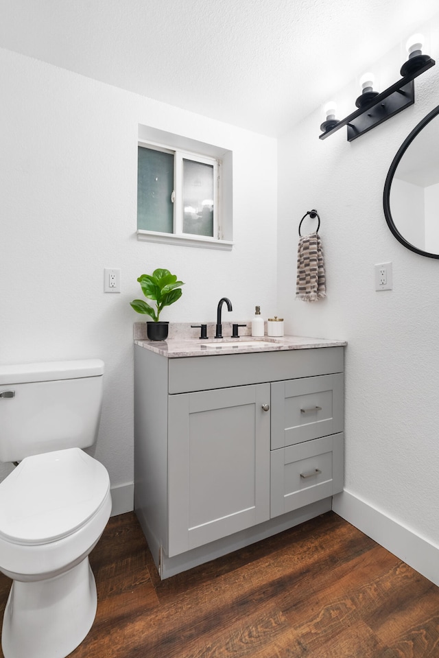 bathroom with vanity, toilet, and hardwood / wood-style flooring